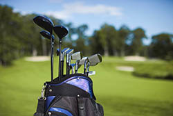 Golf bag and clubs against defocused course background