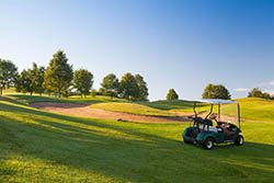 Green golf cart on the empty golf course