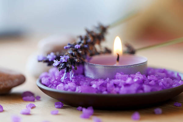 Candle in a saucer with salt baths and sprigs of lavender