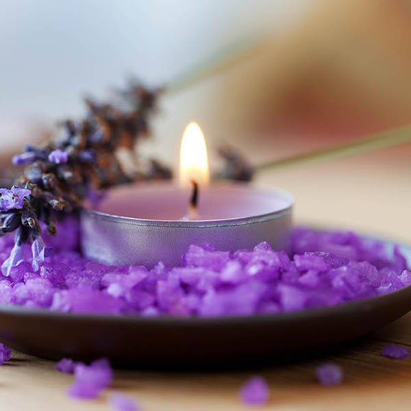Candle in a saucer with salt baths and sprigs of lavender