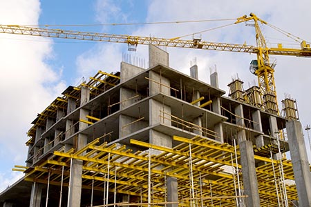 crane near building on cloudly sky horizontal